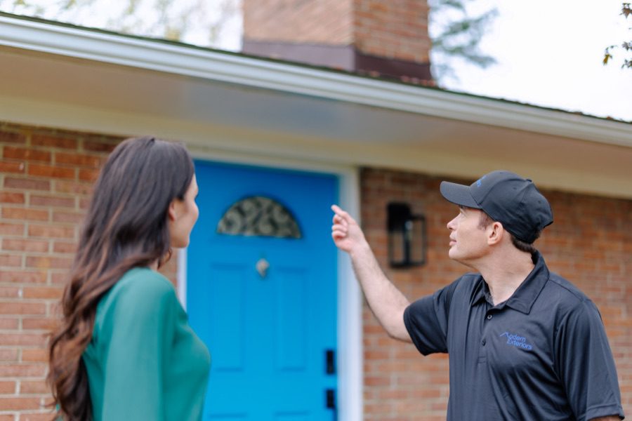roofing contractor talking with homeowner outside about roof